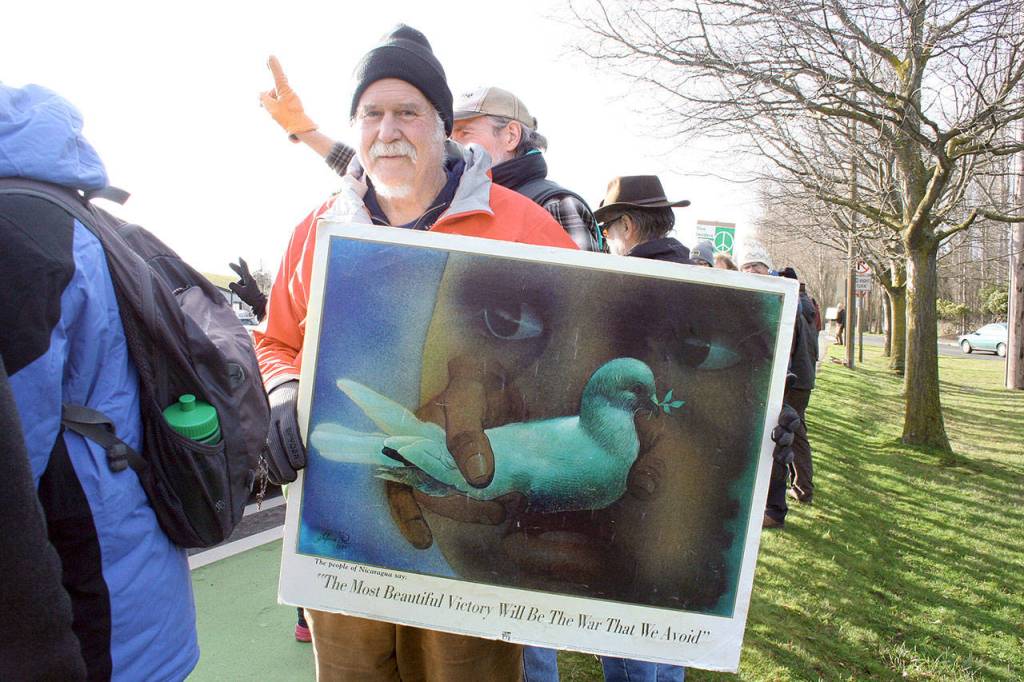 Doug Milholland of Port Townsend lines up on East Sims Way near the intersection with Kearney Street, along with about 100 people, on Thursday during the No War protest in Port Townsend. The event, organized by Indivisible Port Townsend, served as a demonstration against U.S. involvement in potential military action with Iran. (Brian McLean/Peninsula Daily News)