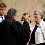 House Speaker Laurie Jinkins, D-Tacoma, second from right, is sworn in by former Washington Supreme Court Chief Justice Mary Fairhurst, second from left, Monday, on the first day of the 2020 session of the Washington legislature at the Capitol in Olympia. (Ted S. Warren/The Associated Press)