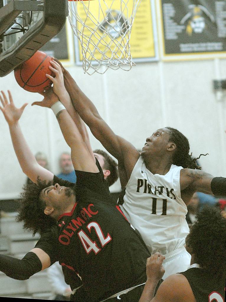 Peninsulas Malik Moore, right, fights for a rebound with Olympics KaShon Tate, left, and Tyler Williford, back, during Saturday nights game in Port Angeles. (Keith Thorpe/Peninsula Daily News)
