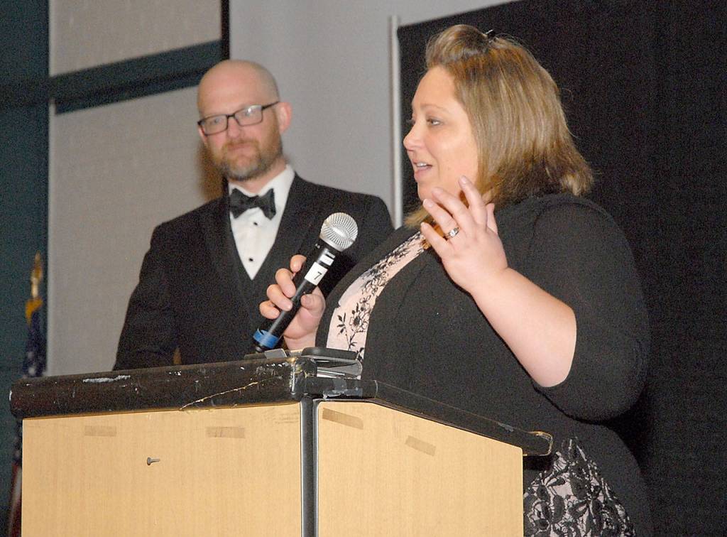 Port Angeles Food Bank Executive Director Emily Dexter, right, accepts the Community Service Award for Organization of the Year as emcee Josh Jones looks on. (Keith Thorpe/Peninsula Daily News)