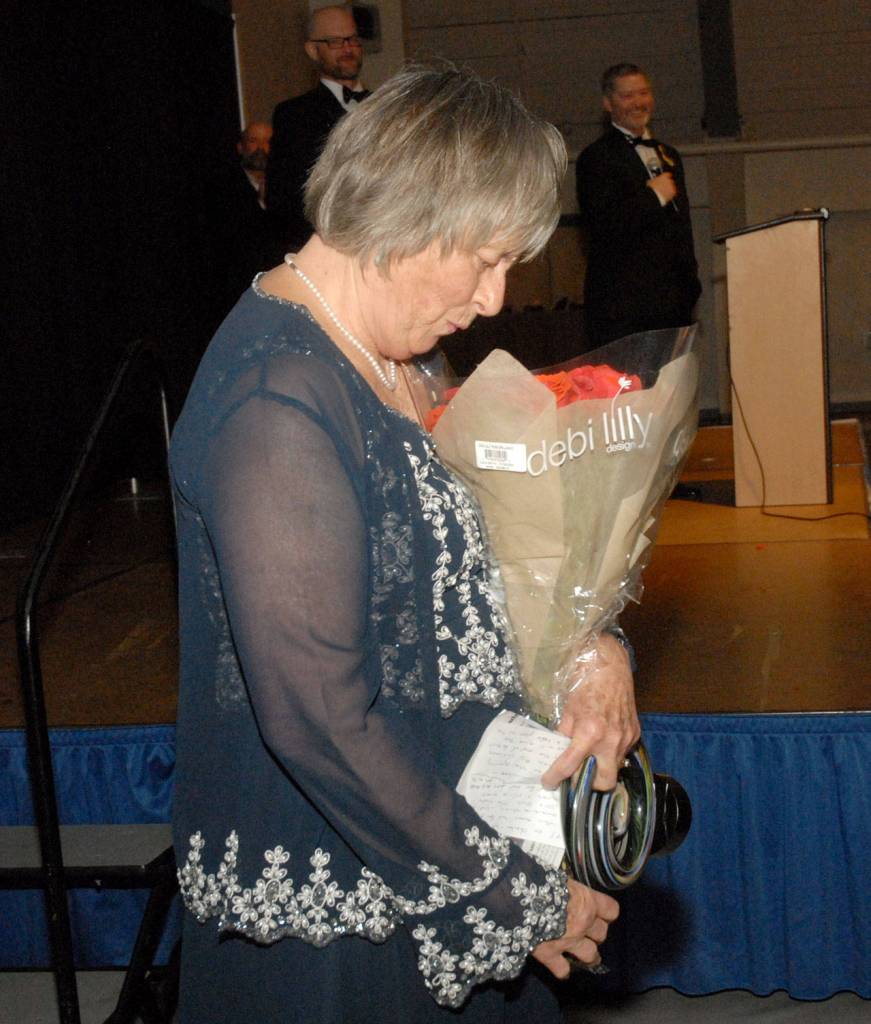 Community Awards Citizen of the Year Norma Turner looks at a bouquet of flowers presented to her after receiving her award. (Keith Thorpe/Peninsula Daily News)