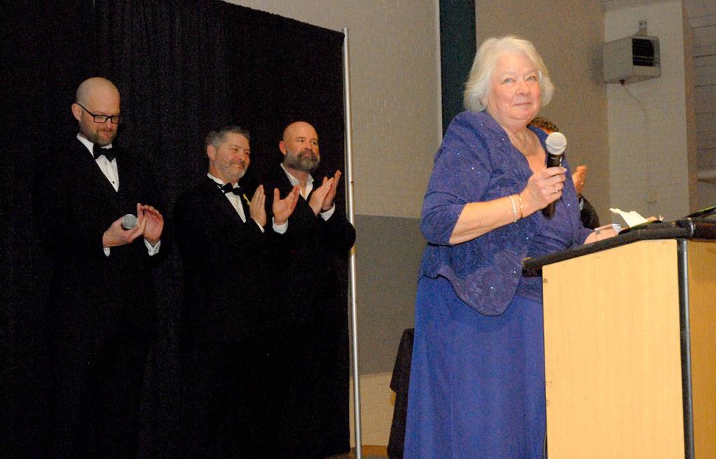 Marie Moran, widow of Port Angeles City Council member Jim Moran, is applauded by presenters, from left, Josh Jones, Tim Tucker and Terry Ward as she speaks after accepting the Chamber of Commerce Legacy Award on behalf of her late husband. (Keith Thorpe/Peninsula Daily News)