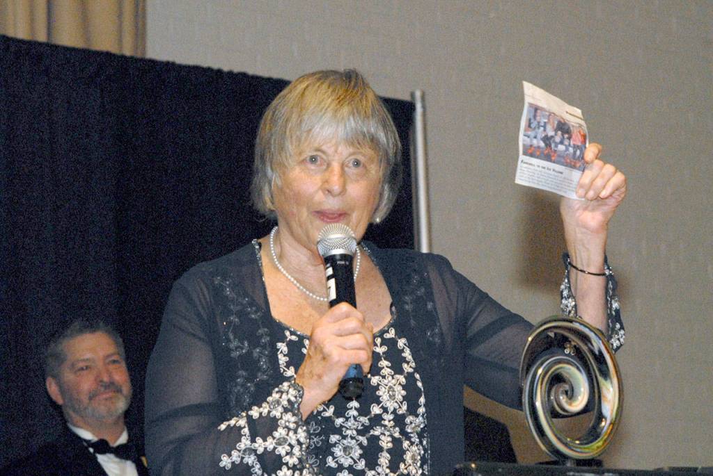 Port Angeles Community Award Citizen of the Year Norma Turner holds up a newspaper clipping of skating children during her acceptance speech. (Keith Thorpe/Peninsula Daily News)