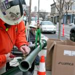 FB Titan Powerline crew member Michael Lake, left, trims electrical wiring from the top of a new street light Monday, Jan. 27, 2020, as foreman Drew Plato secures the opposite end. (Brian McLean/Peninsula Daily News)
