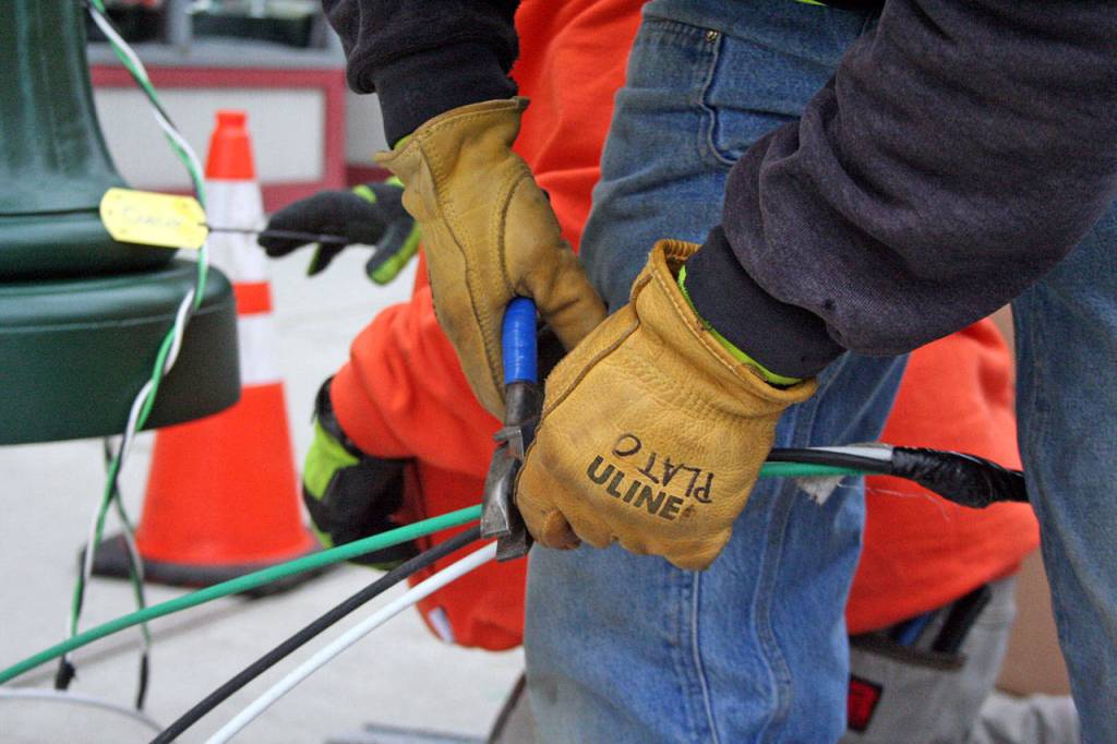 FB Titan Powerline Foreman Drew Plato cuts excess wire just before a new street light is secured to its base on Monday, Jan. 27, 2020. (Brian McLean/Peninsula Daily News)
