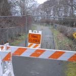 Barricades, construction fencing and a warning sign block a section of the Olympic Discovery Trail near Four Seasons Ranch east of Port Angeles near the site where human remains were discovered near a storm-damaged portion of the trail. (Keith Thorpe/Peninsula Daily News)