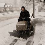 Joshua Bolton of the North Olympic Library System plows the sidewalk on Peabody Street next to the Port Angeles Library on Monday morning. (Dave Logan/for Peninsula Daily News)