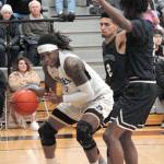 Peninsulas Malik Moore, left, tries to squeeze between Belluvues Trey Lawrence, back, and Gerald Hood, right, during Wednesdays NWAC North Division game in Port Angeles. (Keith Thorpe/Peninsula Daily News)