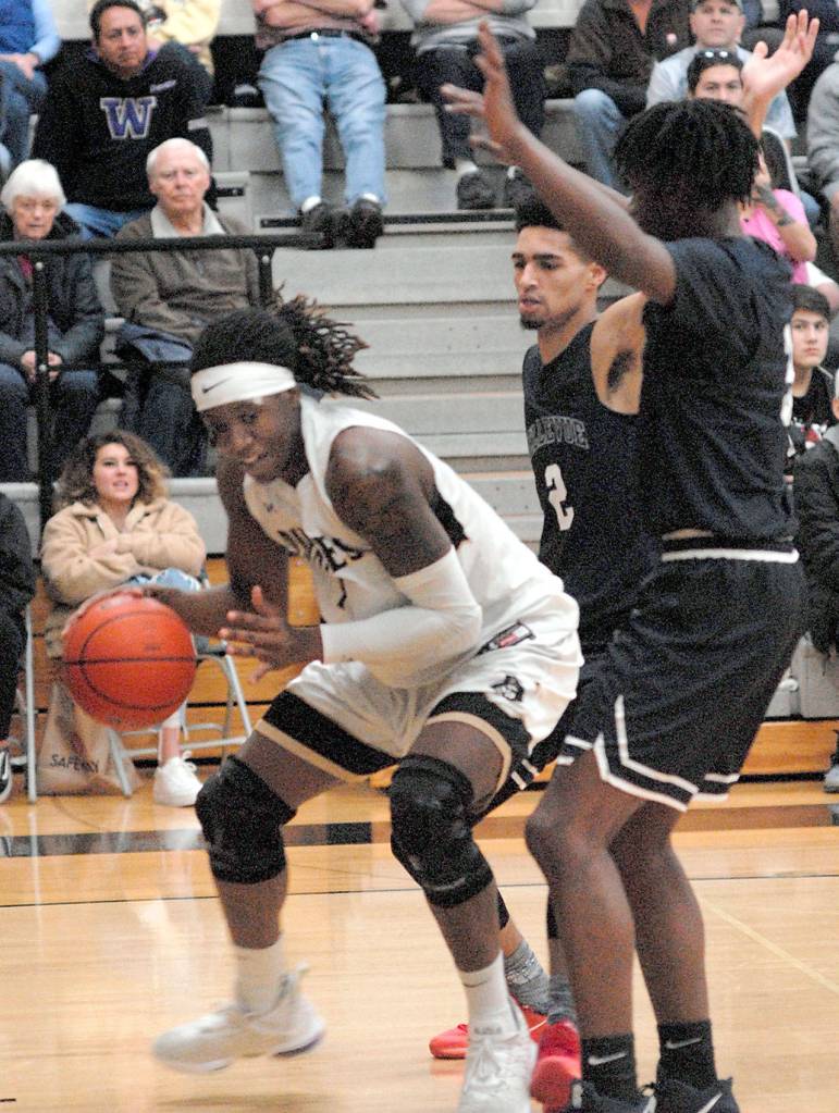 Peninsulas Malik Moore, left, tries to squeeze between Belluvues Trey Lawrence, back, and Gerald Hood, right, during Wednesdays NWAC North Division game in Port Angeles. (Keith Thorpe/Peninsula Daily News)