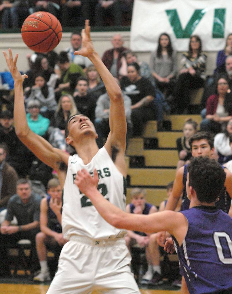 Keith Thorpe/Peninsula Daily News Port Angeles Damen Ringgold, left, retrieves a rebound as Sequims Dallin Despain, right, looks on at Port Angeles High School on Thursday.