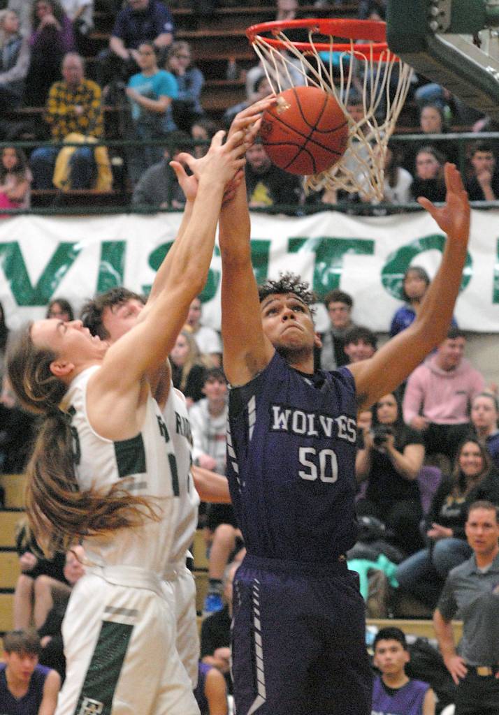 Port Angeles Derek Bowechop, left, and Gary Johnson battle for a rebound with Sequims Hayden Eaton on Thursday night at Port Angeles High School. (Keith Thorpe/Peninsula Daily News)