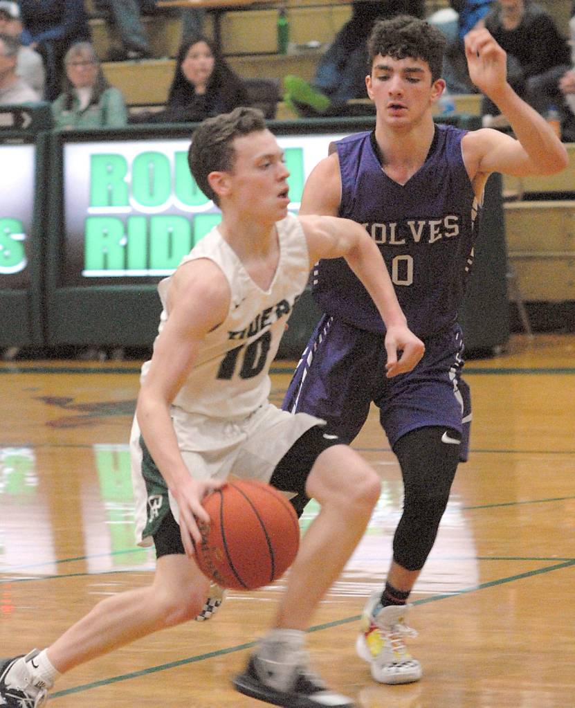 Port Angeles Dru Clark, left, charges past Sequims Dallin Despain at Port Angeles High School on Thursday. (Keith Thorpe/Peninsula Daily News)