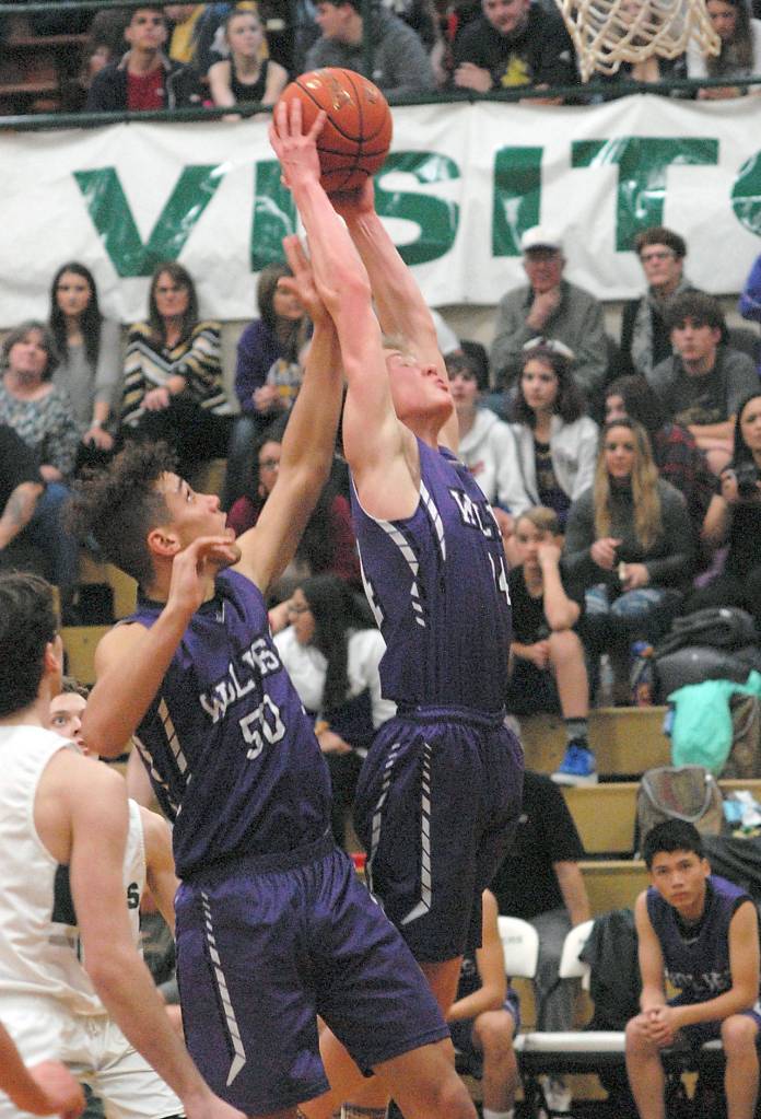 Sequims Erik Christiansen, right, with help from teammate Hayden Easton, pulls down a rebound as Port Angeles Nolan Hughes, left, looks on during Thursdays game in Port Angeles. (Keith Thorpe/Peninsula Daily News)