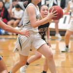 Port Angeles Bailee Larson, front, is chased to the lane by Sequims Hannah Bates during Thursdays showdown at Port Angeles High School. (Keith Thorpe/Peninsula Daily News)