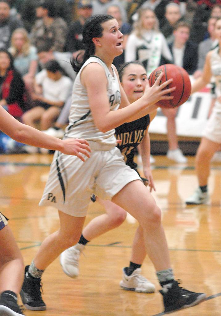 Port Angeles Bailee Larson, front, is chased to the lane by Sequims Hannah Bates during Thursdays showdown at Port Angeles High School. (Keith Thorpe/Peninsula Daily News)