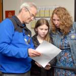 Crescent School Superintendent Dave Bingham, left, looks over election results with school board member Susan Hopper and her daughter, Mariah Hopper, 10, on Tuesday night at the Clallam County Courthouse. (Keith Thorpe/Peninsula Daily News)