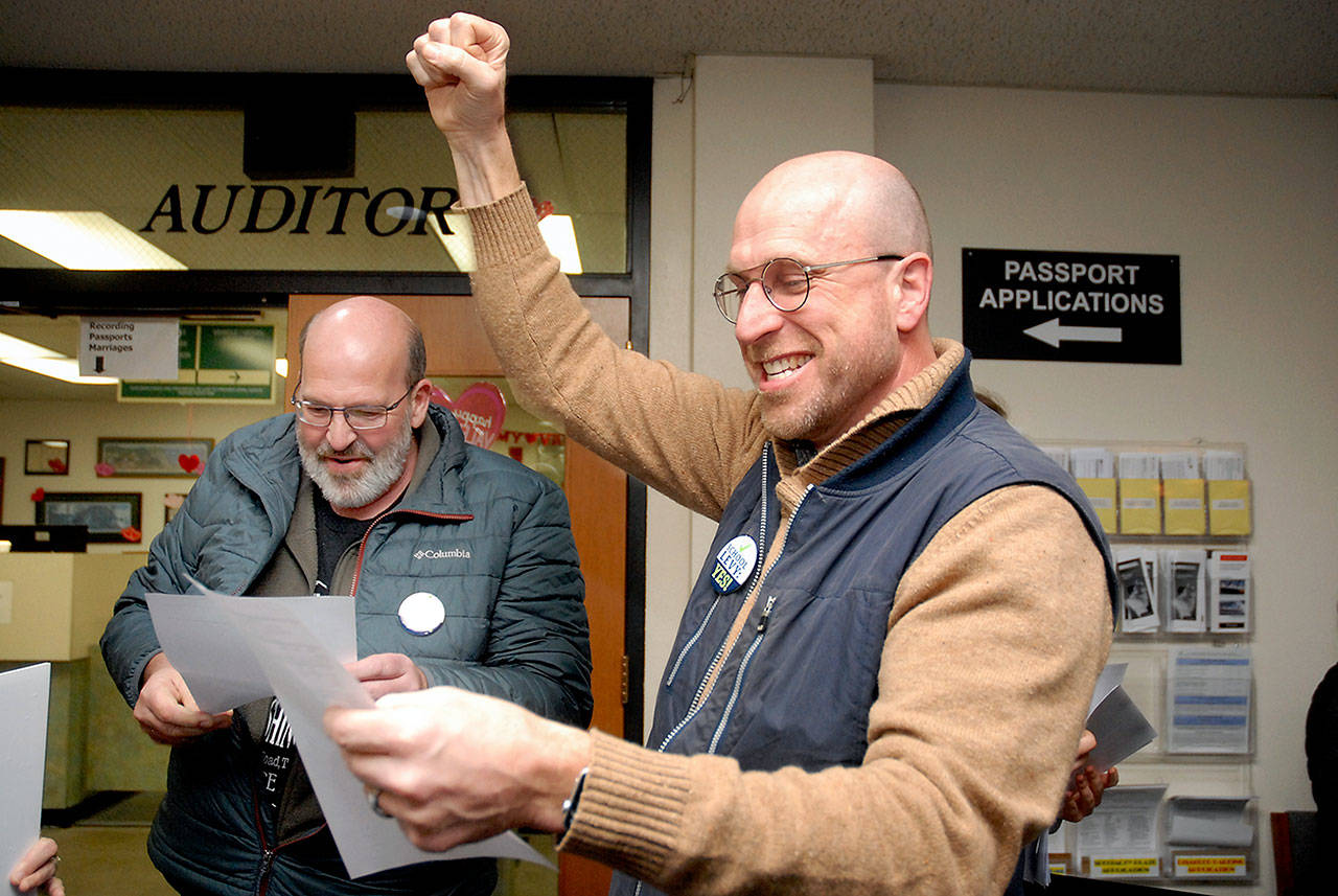 Steve Methner, committee chair for Port Angeles Citizens for Education, right, raises a fist in celebration as fellow committee member Nolan Duce looks over ballot results that showed a capital levy for the Port Angeles School District passing after Tuesdays initial count. (Keith Thorpe/Peninsula Daily News)