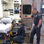 Paramedic Mike Ingraham, left, checks the functionality of a new ambulance stretcher while senior EMT Todd German assists. (Laura A. Foster/Peninsula Daily News)