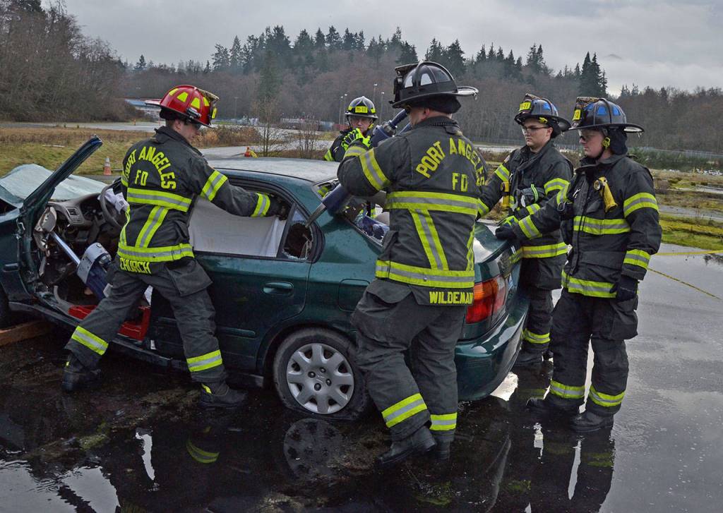 Port Angeles Fire Department B Shift practices safely rescuing a victim from being entrapped in a car. (Laura Foster/Peninsula Daily News)