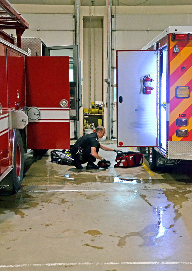 Paramedic Doug Eaton checks supplies from an ambulance in the Port Angeles Fire Department truck bay at the beginning of a 24-hour shift. (Laura A. Foster/Peninsula Daily News)