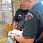 Paramedic Tyler Gage, right, marks on a rig checklist as senior EMT Todd German verifies. (Laura A. Foster/Peninsula Daily News)