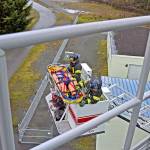 Paramedics Tyler Gage and Mike Ingraham descend to the ground after securing a patient during a ladder rescue drill. (Laura A. Foster/Peninsula Daily News)