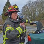 Capt. Kelly Ziegler of the Port Angeles Fire Department gives orders to the crew for a victim extraction drill at the old Rayonier site. Using a car donated by Peninsula College, the team was tasked with safely removing a mannequin from the vehicle using manual and power tools. (Laura A. Foster/Peninsula Daily News)