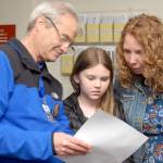 Crescent School Superintendent Dave Bingham, left, looks over election results with school board member Susan Hopper and her daughter, Mariah Hopper, 10, on Tuesday night at the Clallam County Courthouse. (Keith Thorpe/Peninsula Daily News)