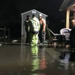City of Sequim staff consult last week about options to resolve flooding issues off Rolling Hills Way in Sequim. Crews brought in a pump and sandbags to take out and keep water out of the homes crawlspace. (Matthew Nash /Olympic Peninsula News Group)