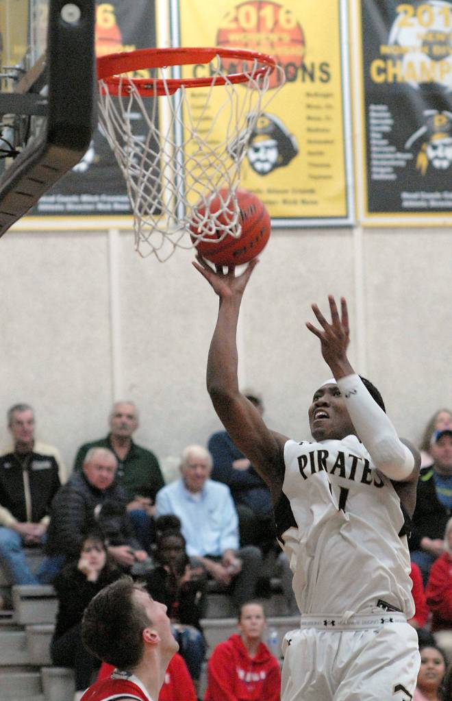 Peninsulas Makil Moore, right, looks for the layup as Skagit Valleys Cade Isakson, lower left, looks on from the lane on Wednesday at Peninsula College. (Keith Thorpe/Peninsula Daily News)