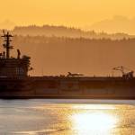 A Navy jet fighter sits at the ready as the USS Nimitz (CVN 68) approaches Naval Magazine Indian Island, located at the south end of Port Townsend Bay, just after sunrise Tuesday. (Steve Mullensky/for Peninsula Daily News)