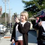 Kate Krusely, left, captures the moment her husband, U.S. Navy Lt. Julian Krusely, steps off a bus Tuesday. Meanwhile, Brian Wright of Los Angeles holds a banner that reads Welcome Home along with his wife, Jennifer (not pictured). (Brian McLean/Peninsula Daily News)