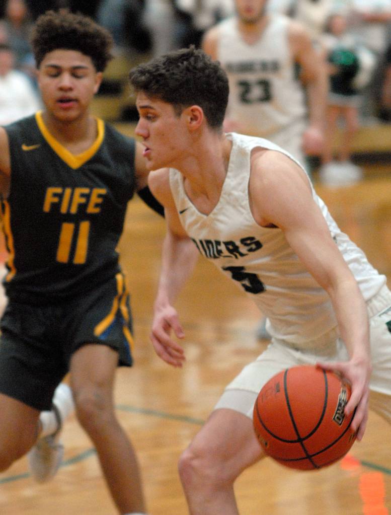 Keith Thorpe/Peninsula Daily News Port Angeles Chase Cobb heads for the lane and Fifes Khalil Messiah defends on Thursday at Port Angeles High School.