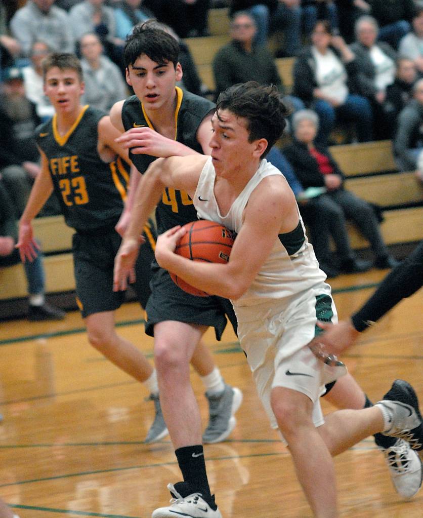 Keith Thorpe/Peninsula Daily News Gary Johnson of Port Angeles charges past Fifes Ivan Gonzalez-Cortez, center, and Kevin Williams, left, during the first quarter on Thursday in Port Angeles.