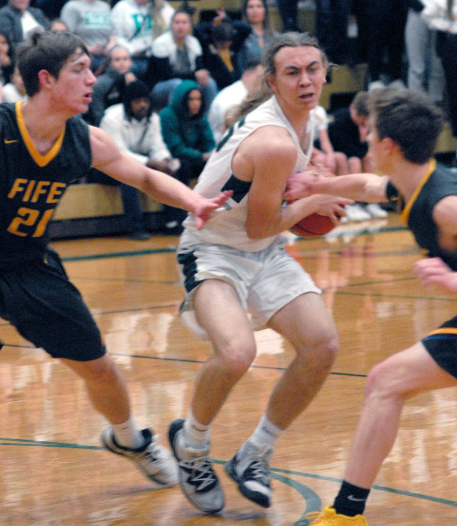 Keith Thorpe/Peninsula Daily News Port Angeles Derek Bowechop, center, holds off Fife defenders Kevin Williams, left, and Kaleb Martin on Thursday night at Port Angeles High School.