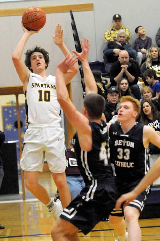 <strong>Lonnie Archibald</strong>/for Peninsula Daily News                                Spartan Carter Windle (10) puts up a shot against Seton Catholics Griffin Young and Andrew Olson (33) Friday in Forks where the Cougars defeated Forks 66-48 in the 1A Southwest District Tournament.