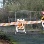 A barricade and construction fencing block access to a portion of the Waterfront Trail, part of the Olympic Discovery Trail, near Four Seasons Ranch on Saturday, Feb. 15, 2020, near the area where Native American burial remains were discovered in January. Weather damage to the trail has delayed opening of the popular trail. (Keith Thorpe/Peninsula Daily News)