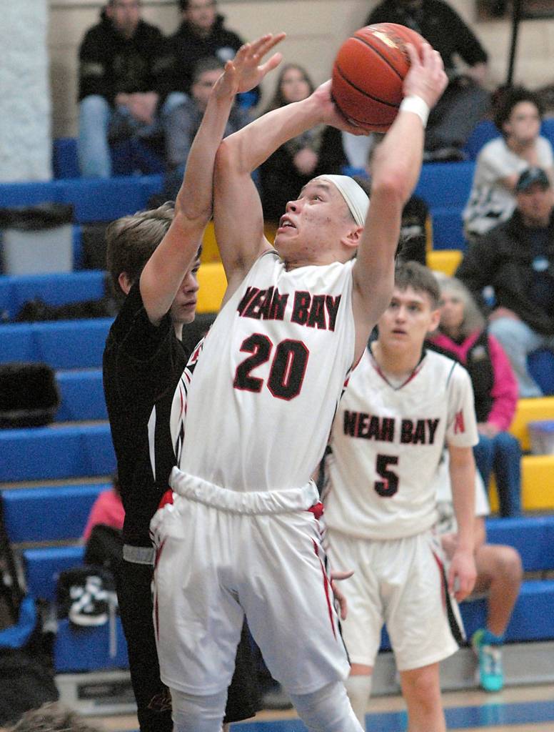 Keith Thorpe/Peninsula Daily News Neah Bays Toby Croy, front, aims for the hoop as Lopez Islands Lichen Johnson defends of Saturday at Cresent High School in Joyce. Looking on at right is Neah Bays Darren Horejsi.
