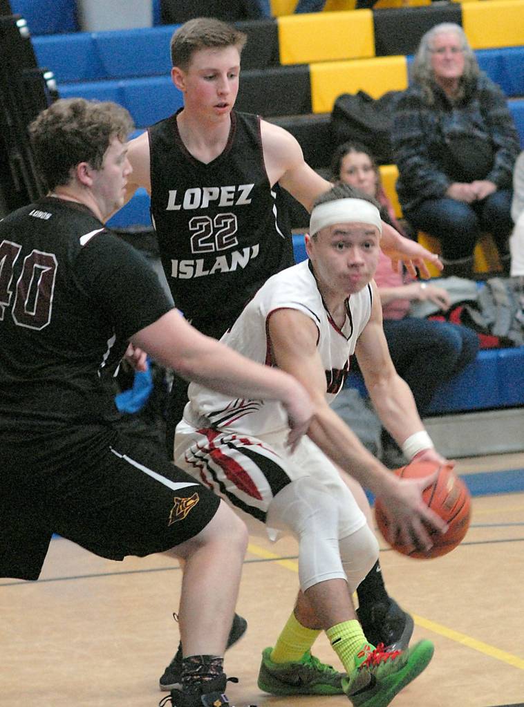 Keith Thorpe/Peninsula Daily News Neah Bays Toby Croy slips past the defense of Lopez Islands Reese Hamilton, left, and Joshua Kramer during the second half on Saturday at Crescent High School in Joyce.