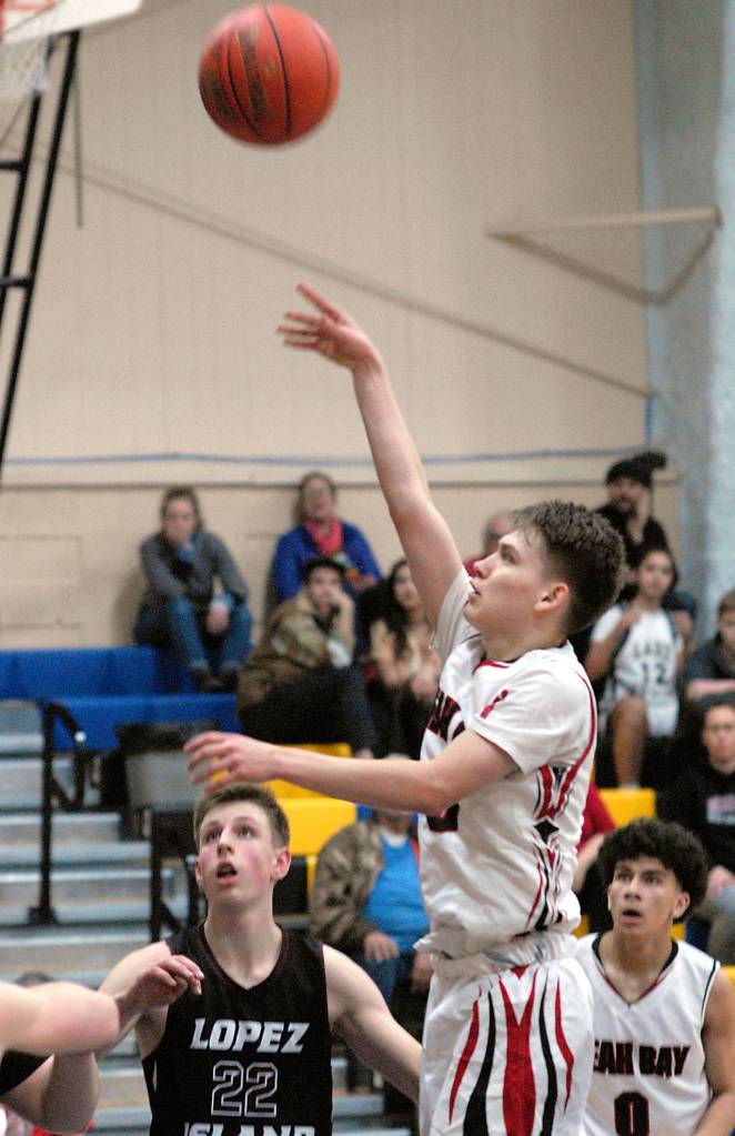 Keith Thorpe/Peninsula Daily News Darrin Horejsi of Neah Bay shoots for the hoop as Lopez Islands Joshua Kramer, left, and Neah Bays Jaxson Halttunen look on during Saturdays game in Joyce.