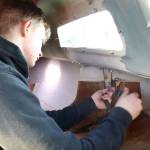 Team Fast Skipper Odin Smith works to remove bolts on a chain plate, so he can remove and replace them on the teams 27-feet-long sloop.(Zach Jablonski/Peninsula Daily News)