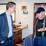 Congressman Derek Kilmer, left, visits with Dave Thomas, 85, of Port Townsend after he delivered him a bag of supplies from the Meals on Wheels program. Kilmer, D-Gig Harbor, said President Donald Trumps proposed budget cuts three programs that social services such as Meals on Wheels rely on to help fill gaps in funding. (Brian McLean/Peninsula Daily News)