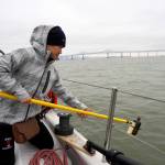 In this August 2017 photo, Alice Zhu, with the University of Toronto, prepares to take a sample of water from San Francisco Bay. The San Francisco Estuary Institute found microplastics in stormwater runoff entering the Pacific Ocean in a three-year study completed in 2019. (Shira Bezalel/San Francisco Estuary Institute via The Associated Press)