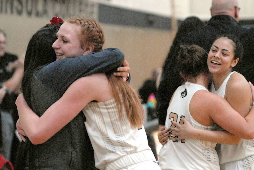 Peninsulas Kameron Bowen, front left, hugs redshirt teammate Cheyenne Wheeler as teammates Leilani Padilla, right, celebrates with teammate Gina McCaulley in the closing seconds of Wednesday nights game against Shoreline in Port Angeles. (Keith Thorpe/Peninsula Daily News)