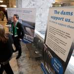 In this Feb. 12, 2020, photo, Mike Gonzalez, center, senior manager of public affairs at the Franklin Public Utility District, stands next to informational signs promoting dams on the Snake River during a lobby day at the Capitol in Olympia, Wash. A federal report released Friday, Feb. 28, rejected the idea of removing four hydroelectric dams on a major Pacific Northwest river in a last-ditch effort to save threatened and endangered salmon. The report says breaching the dams would destabilize the power grid, increase greenhouse emissions and raise the risk of power outages. (AP Photo/Ted S. Warren)