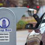 A voter drops off a ballot at the Clallam County Courthouse in this 2018 file photo. (Jesse Major/Peninsula Daily News file)