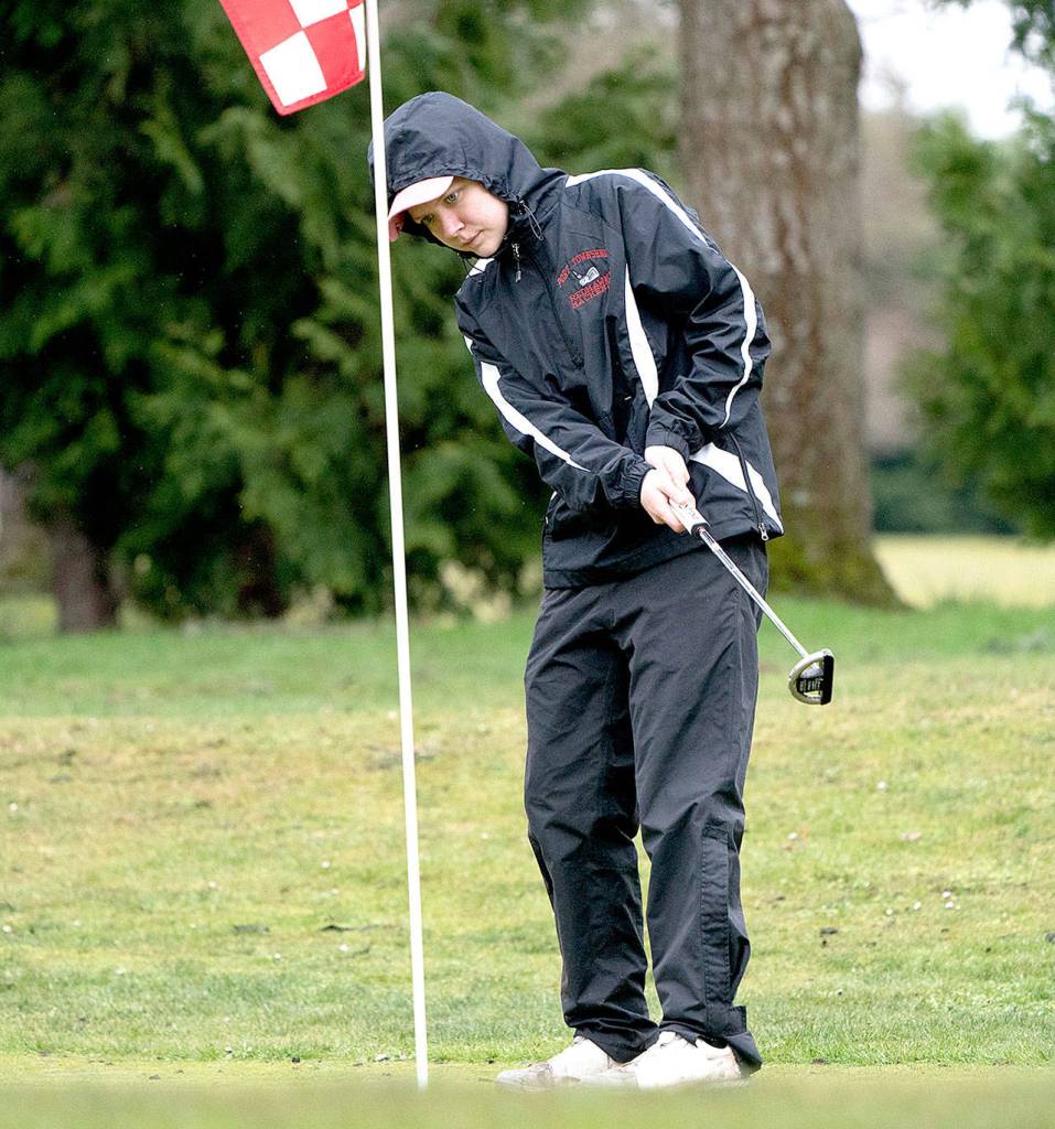 Steve Mullensky/for Peninsula Daily News                                 Port Townsends Mackenzie Lake watches her ball roll towards the cup during a golf match against Port Angeles on Friday at Port Townsend Golf Course.