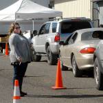 Port Angeles Food Bank Executive Director Emily Dexter talks with food bank patrons as they line up in their vehicles to receive food boxes on Friday. (Keith Thorpe/Peninsula Daily News)