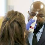 Relwende Guiguemde, right, has his temperature taken by Angie Webb, left, a nurse at Western State Hospital, on Thursday, March 19, 2020, as he arrives at a visitors entrance for a job interview in Lakewood. A patient and a worker at the facility, Washington states largest psychiatric hospital, have tested positive for the new coronavirus. (Ted S. Warren/The Associated Press)