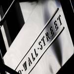 This July 15, 2013, file photo shows a sign for Wall Street outside the New York Stock Exchange. Global stock markets are sharply lower on deepening worries over damage from the coronavirus pandemic. Benchmarks fell in Paris, London and Frankfurt on Wednesday, April 1, 2020. (Mark Lennihan/The Associated Press file)